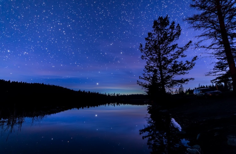 Photo of night sky with stars over a lake