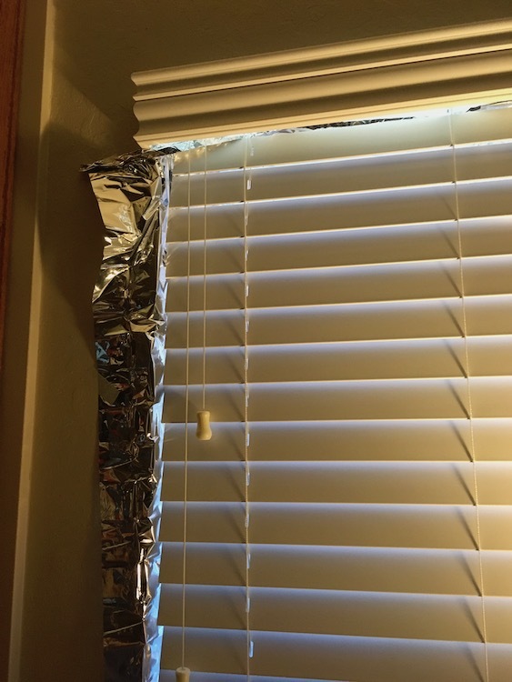 Image of reflective material peeking out from window blinds