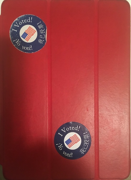 Photo of red iPad cover with two I voted stickers on it