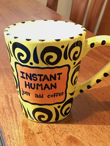 Photo of a yellow coffee mug with the phrase Instant Human just add coffee