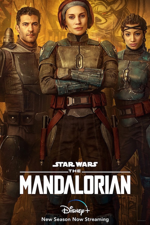 Bo-Katan and companions poster for The Mandalorian. A man on the left, a woman in the center with her arms crossed over her chest, and a woman standing hip-cocked on the right. All three wear armored pieces on shoulders, chest, and upper thighs.