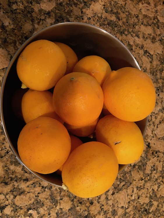 A metal bowl full of fresh lemons