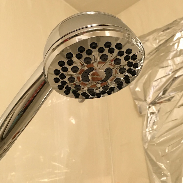 Photo of a round, chrome colored shower head and stalk