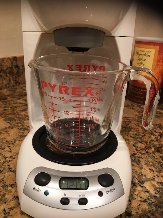 Photo of a glass Pyrex measuring cup sitting on a coffee maker's hot plate