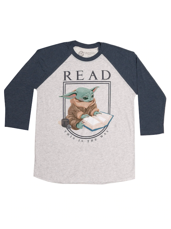 White ¾ length sleeve t-shirt with dark blue arms and a heather white torso. In the center, Grogu is reading a book. Underneath him are the words This Is the Way